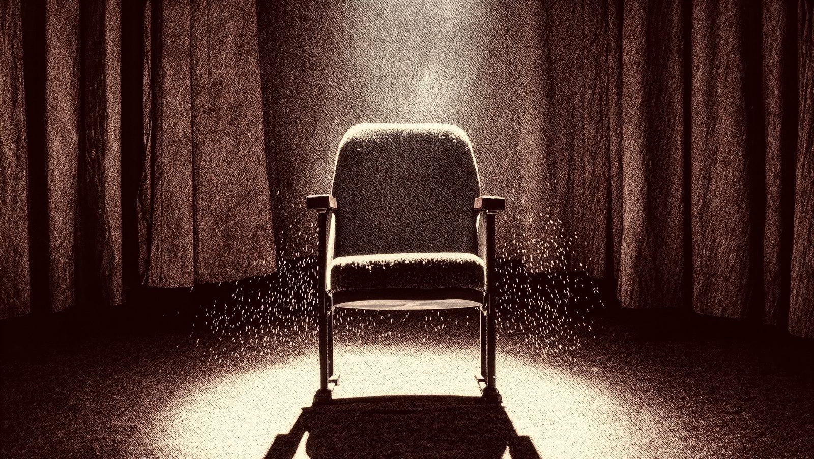 Butaca de teatro vacía bajo un foco de luz, imagen simbólica de homenaje y respeto