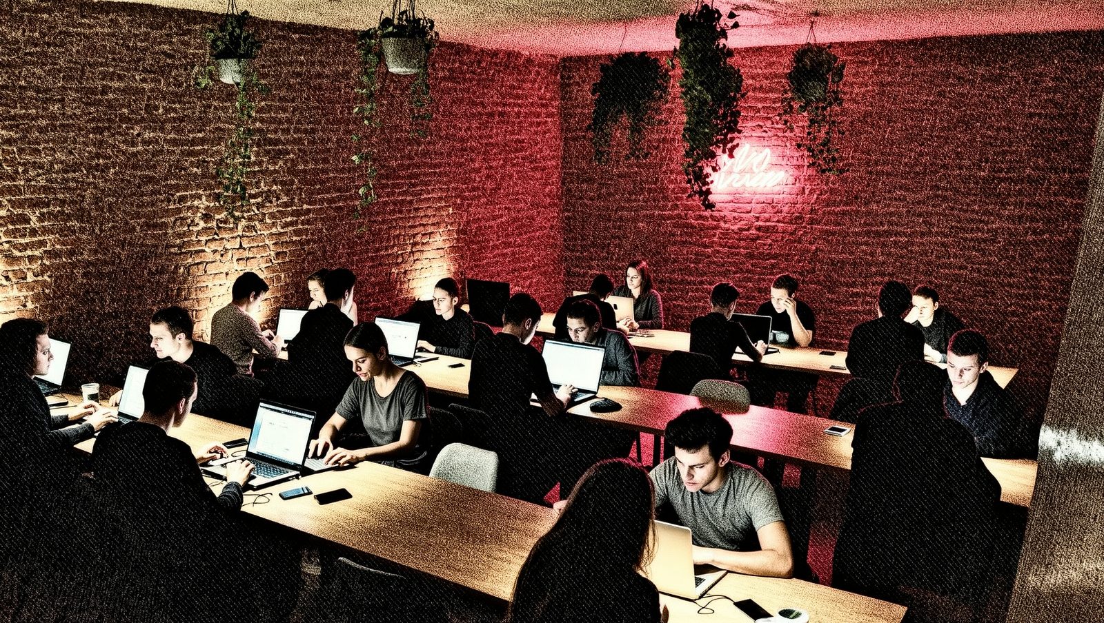 Interior de un espacio de coworking con gente trabajando en portátiles, estilo grunge retro